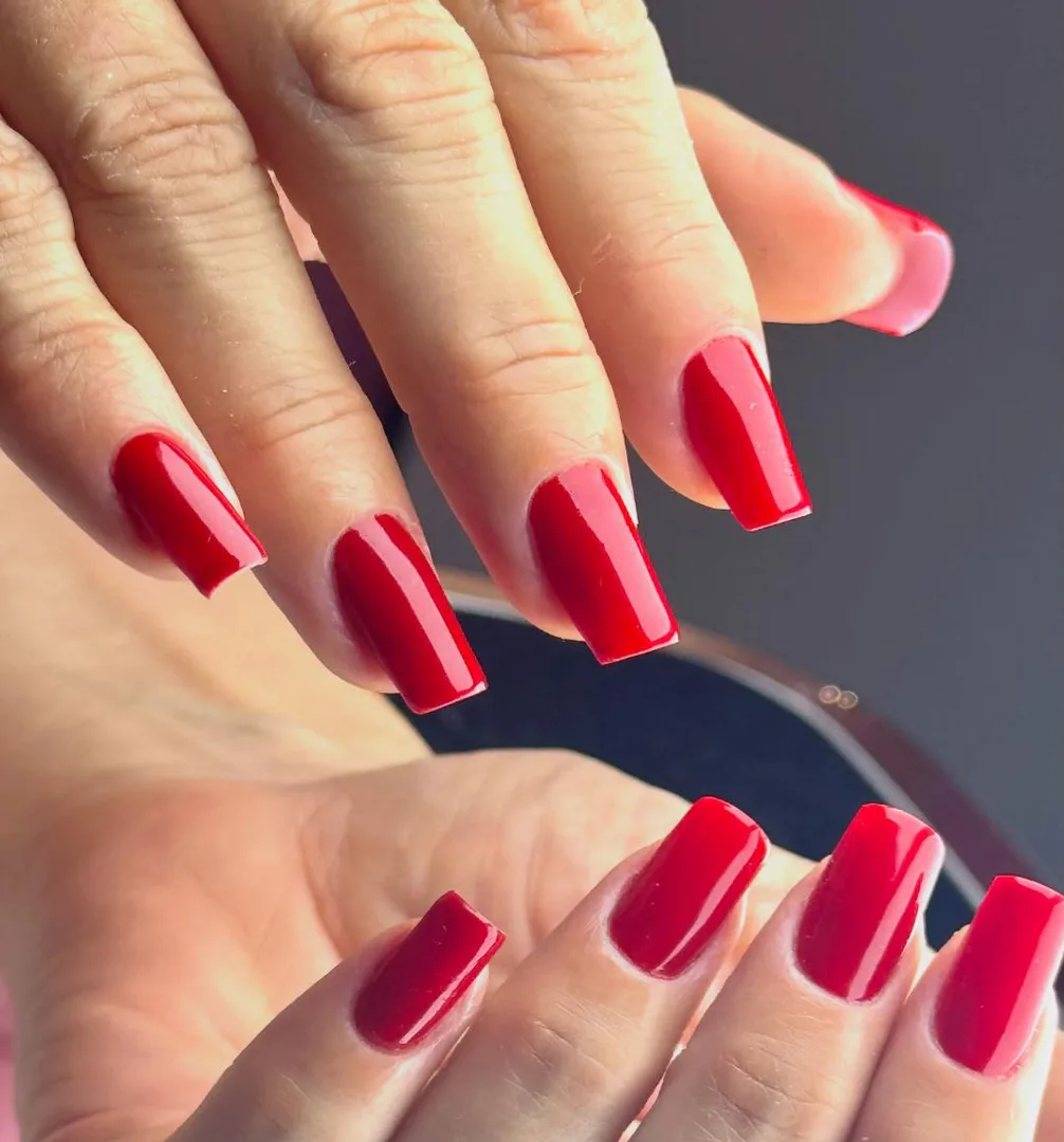 Unhas quadradas esmaltadas em vermelho brilhante